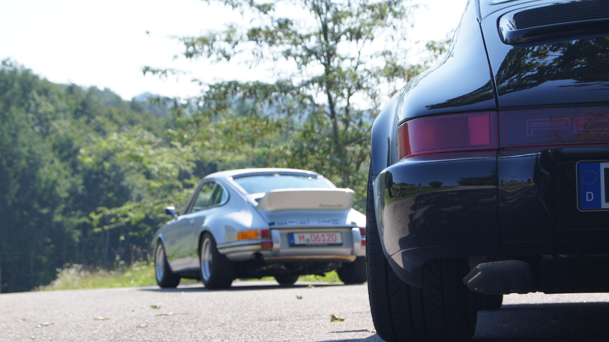 Zwei Porsche 911 auf einer Landstraße